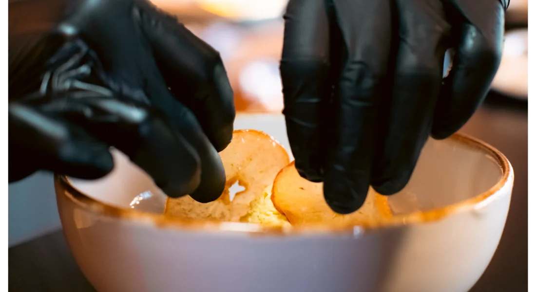 Gloved hands by private chef prepare food